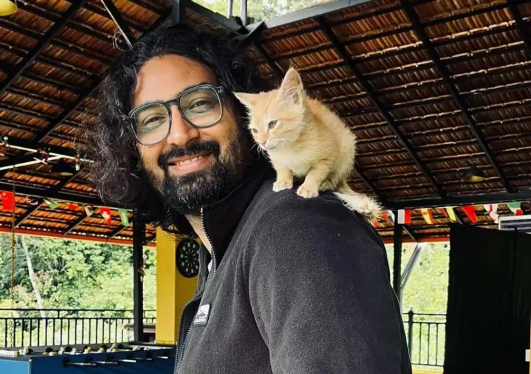 Ravi Gupta posing while a cat is sitting on his soldier